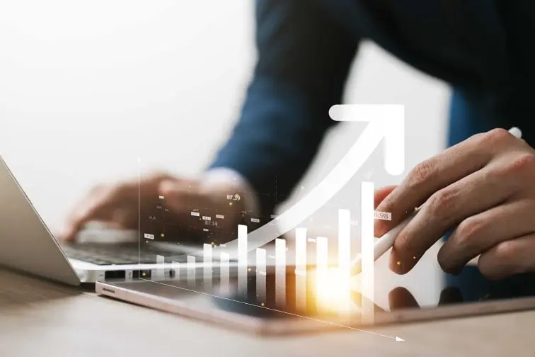 Male hands using laptop and iPad with growth graph overlay